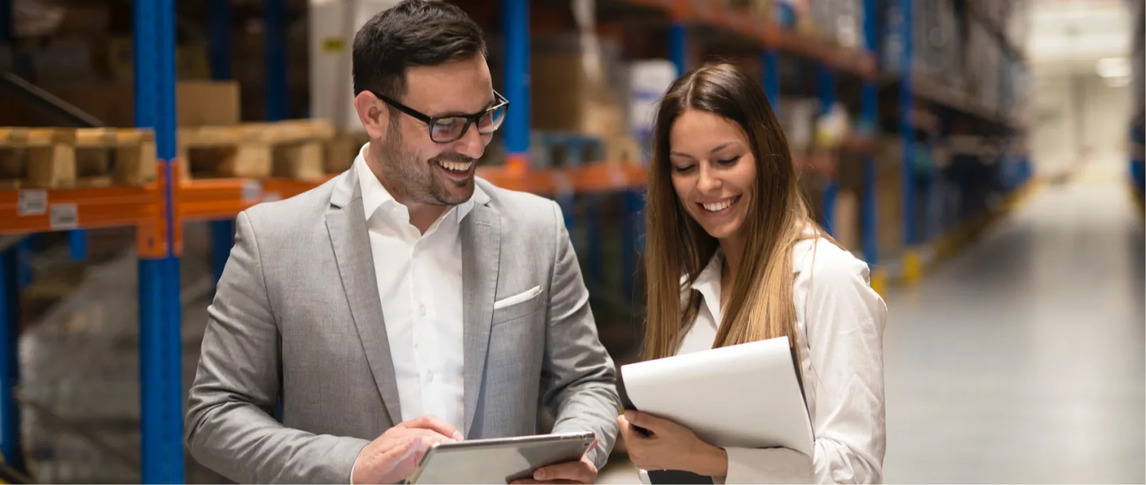 Business professionals reviewing shipping options in a warehouse – choosing the best shipping company for business needs